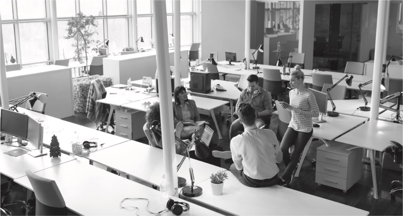 A photograph of office colleagues gathered round for a meeting.